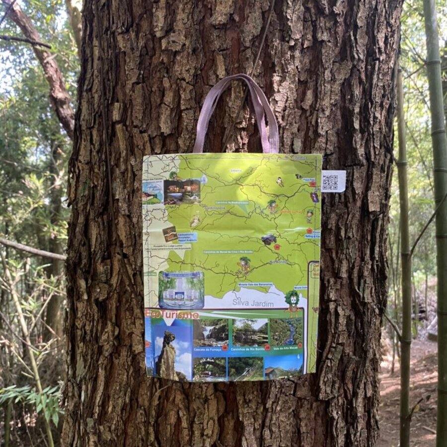 Bolsinha de Papel Costurado feita com mapa turístico de EcoTurismo, pendurada em uma árvore