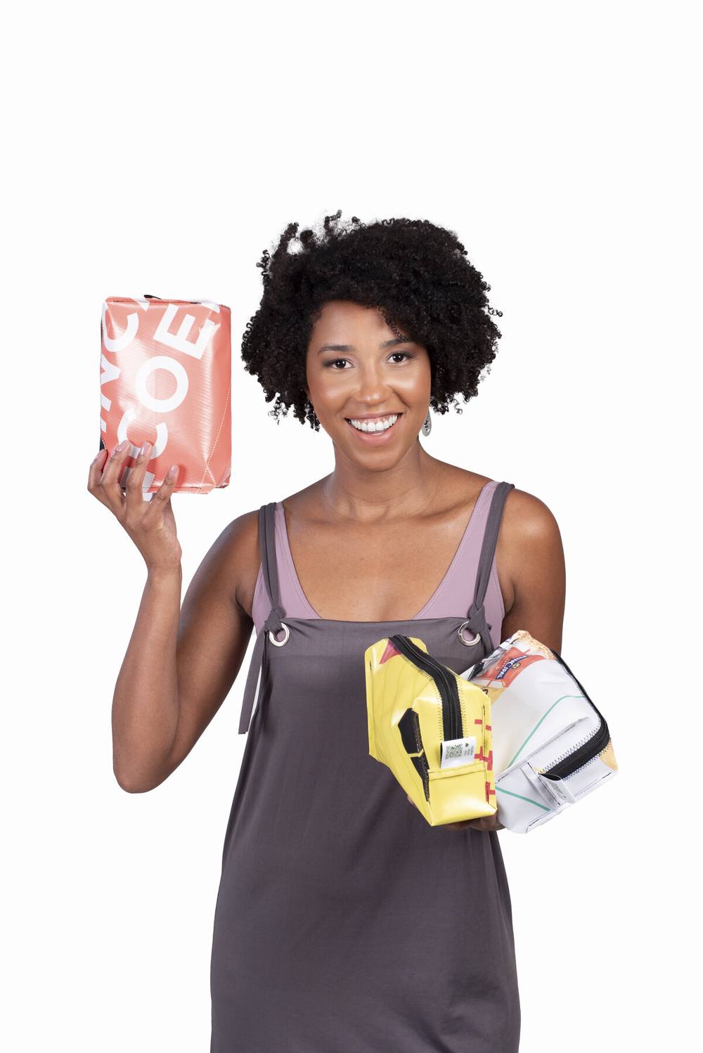 Modelo com necessaires feitas de banner publicitário reaproveitado