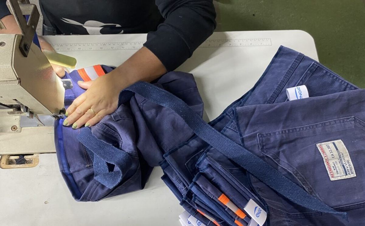 Costureira da EcoModas confeccionando produto a partir de uniforme reaproveitado