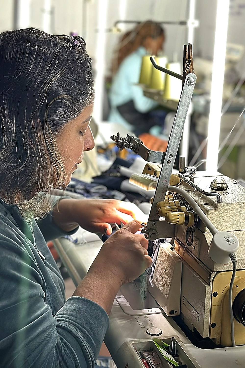Costureira da EcoModas confeccionando produto a partir de uniforme reaproveitado
