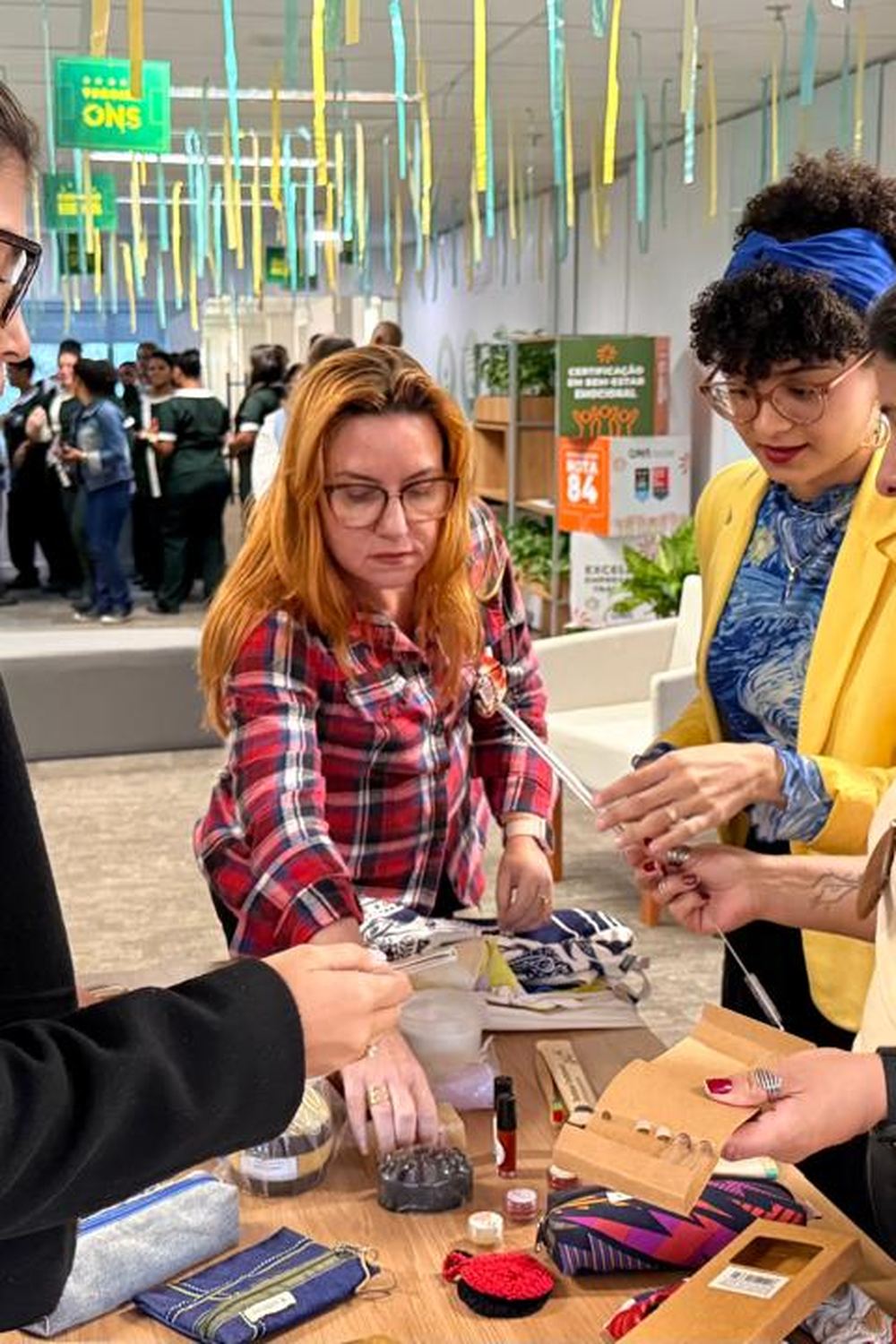 Colaboradoras conhecendo produtos sustentáveis da EcoModas durante o treinamento