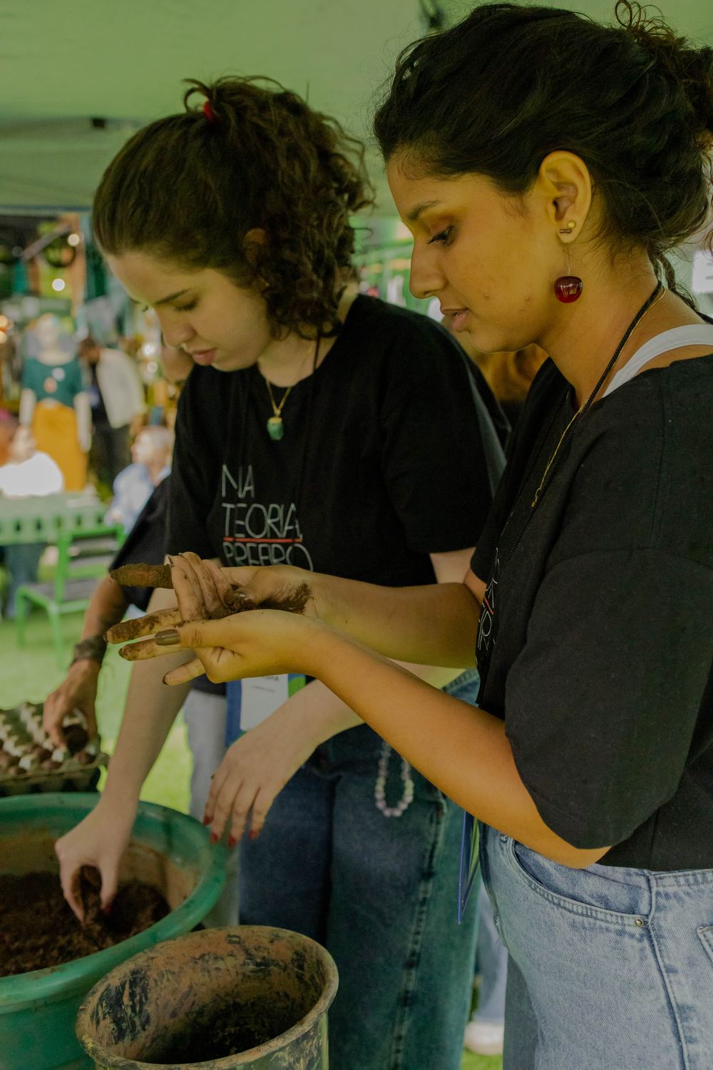 Participantes com as mãos na terra durante atividade prática