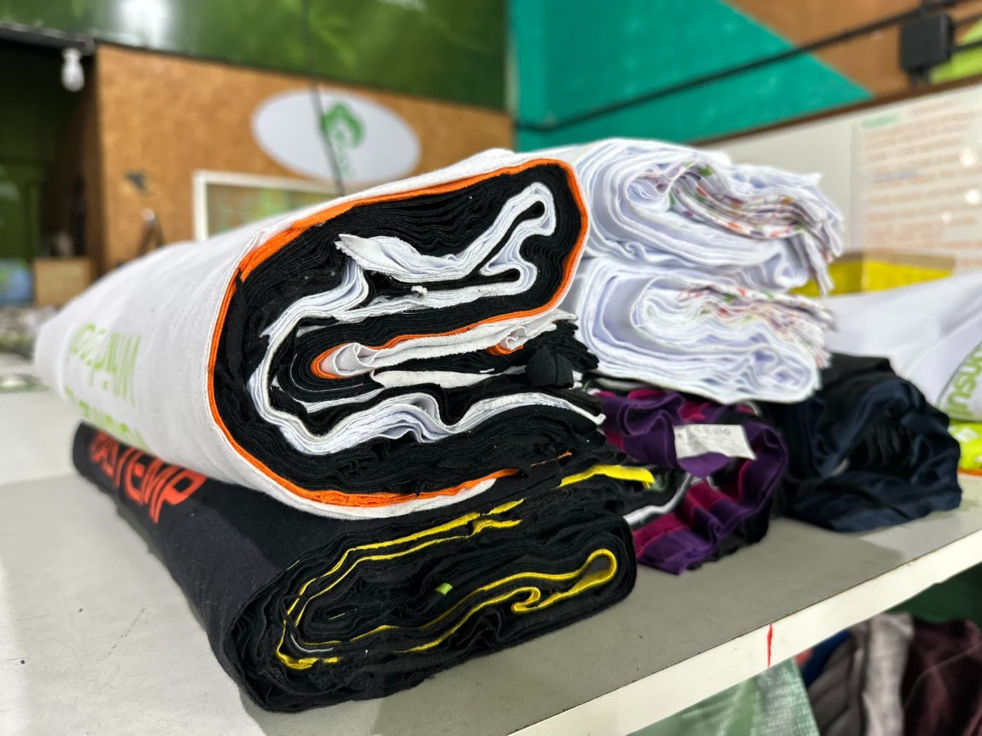Uniformes separados por cor e tecido, prontos para virar novos produtos