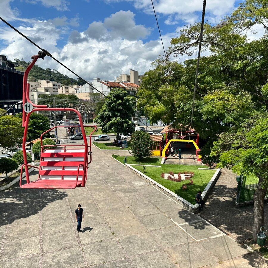 Cadeira do teleférico de Nova Friburgo sobre a praça, próxima à estação de embarque