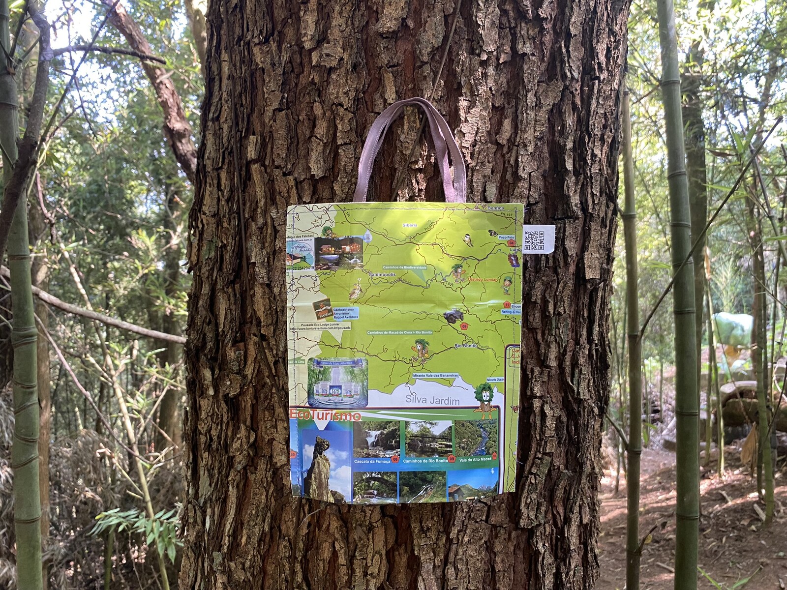 Bolsinha de Papel Costurado, feita com mapa turístico reaproveitado, pendurada em uma árvore